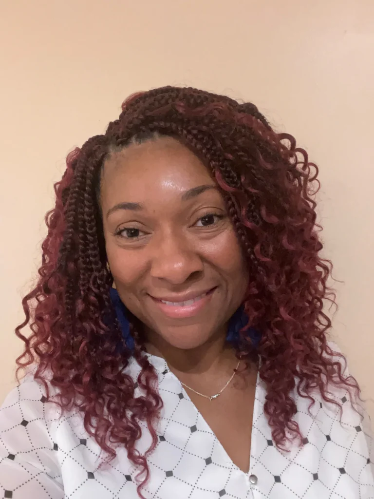 Smiling client with shoulder-length burgundy curls — Crochet Braids